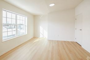 Wadsworth apartment for rent - Empty room with wooden floor and large windows.