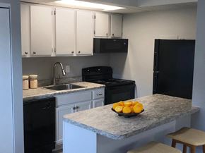 Groveport apartment for rent - a kitchen with black appliances and a counter with a bowl of fruit
