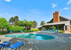 Groveport apartment for rent - a swimming pool with blue chairs in front of a house