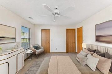 Groveport apartment for rent - A living room with a beige couch and a white ceiling fan.