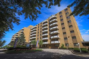 Euclid apartment for rent - a large building with flags in front of it and a blue sky
