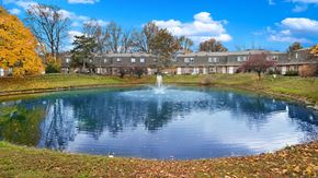 Columbus apartment for rent - a pond with a fountain in front of a building