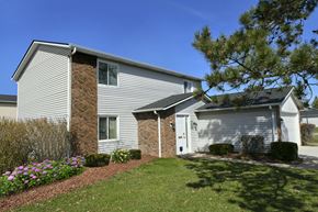 Lorain apartment for rent - a white house with a stone wall and a white garage