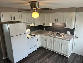Lorain apartment for rent - a kitchen with white cabinets and a white refrigerator