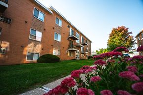 Garfield Heights apartment for rent - a brick building with grass and flowers in front of it