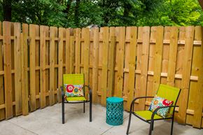 Columbus apartment for rent - A yellow chair with a floral pillow sits in front of a wooden fence.