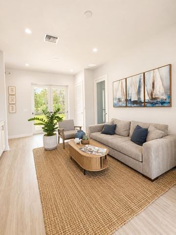 Fort Pierce apartment for rent - A living room with a couch, a chair, a coffee table, and a painting on the wall.