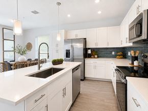 Fort Pierce apartment for rent - A modern kitchen with white cabinets and a black countertop.