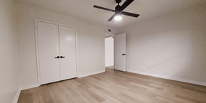 Denton apartment for rent - an empty living room with white walls and a ceiling fan