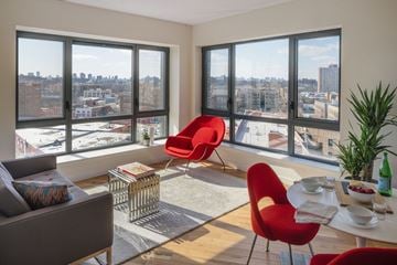 Bronx apartment for rent - A living room with a view of the cityscape through large windows.