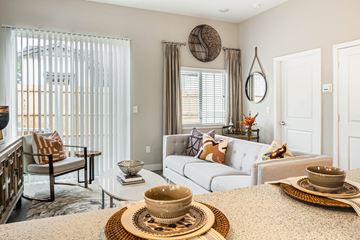 Jenks apartment for rent - A living room with a white couch and a coffee table with a bowl on it.