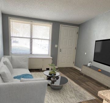 Newnan apartment for rent - A living room with a white couch and a grey armchair.