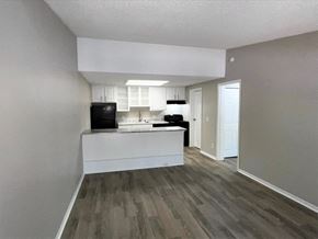 Newnan apartment for rent - A kitchen with a black fridge, white cabinets, and a white island