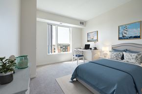 Brooklyn Center apartment for rent - a bedroom with a bed and a desk with a computer at Sonder Point 50+ Apartments, Brooklyn Center, MN, 55430
