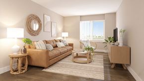 San Tan Valley apartment for rent - A living room with a brown sofa, a wicker table, and a flat screen TV.
