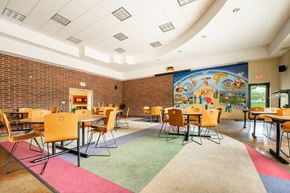 St Paul apartment for rent - a dining room with tables and chairs and a mural on the wall at Ames Lake Neighborhood Apartments, St. Paul, MN