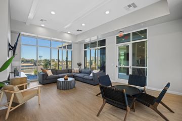 Maricopa apartment for rent - A living room with a grey couch, a black chair and a wooden table.