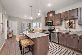 Brooklyn Park apartment for rent - A kitchen with brown cabinets and a white island.at Decatur Landing I & II, Brooklyn Park, MN 55445