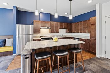A kitchen with a large island with three stools