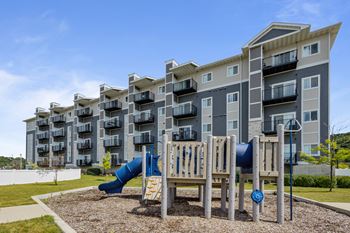 An apartment building with a playground in front of it