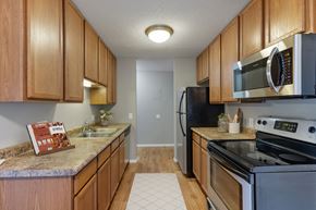 Bloomington apartment for rent - A kitchen with wooden cabinets and a granite counter top at Heritage Hills Apartments, Minnesota, 55437
