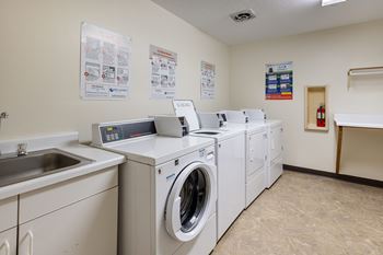 A washer and dryer facility with laundry machines and a sink