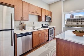 St Paul apartment for rent - a kitchen with wooden cabinets and stainless steel appliances and a window at Press House Apartments, St Paul, 55101