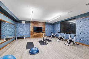St Paul apartment for rent - a gym with exercise equipment and a tv on the wall at Press House Apartments, St Paul, MN, 55101