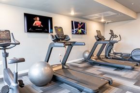 Rochester apartment for rent - four treadmills and exercise balls in a gym with televisions on the wall at Technology Park Apartments, Rochester, MN