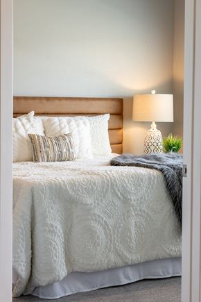Rochester apartment for rent - a bedroom with a bed and pillows and a lamp at Technology Park Apartments, Minnesota, 55901