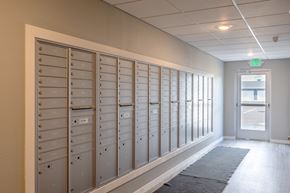 Rochester apartment for rent - a row of lockers in a hallway with an exit door at Technology Park Apartments, Rochester, Minnesota