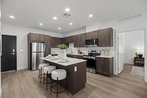 San Tan Valley apartment for rent - A modern kitchen with dark brown cabinets and a white island.