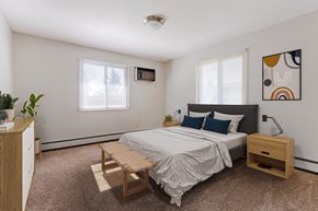 Brooklyn Park apartment for rent - a bedroom with a bed and a dresser and two windows at Villa Del Coronado Apartments, Brooklyn Park, Minnesota