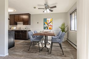 Brooklyn Park apartment for rent - an open kitchen and dining room with a table and chairs and a ceiling fan at Villa Del Coronado Apartments, Minnesota