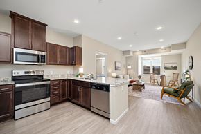 West St Paul apartment for rent - A kitchen with brown cabinets and stainless steel appliances at The Winslow 62+ Apartments, Minnesota, 55118