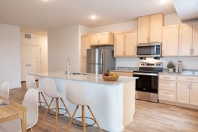 St. Louis Park apartment for rent - a kitchen with a large island with white chairs and a counter top