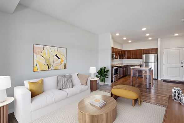 Rochester apartment for rent - A modern living room with a white sofa and a yellow ottoman at EastGate Apartments, Minnesota