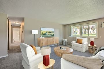 Spring Lake Park apartment for rent - A living room with a white couch, a red lamp, and a painting of a landscape on the wall.