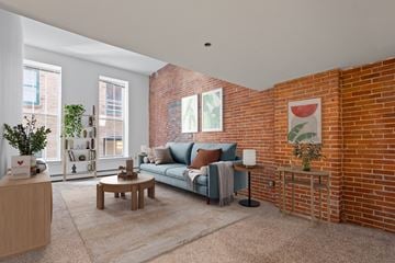 St. Paul apartment for rent - A living room with a blue couch and a brick wall.