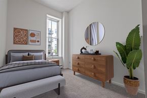 St. Paul apartment for rent - A bedroom with a bed, dresser, and mirror. at Parkside Apartments, St. Paul