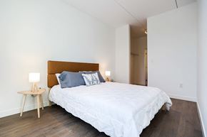 Winnipeg apartment for rent - a bedroom with white walls and a bed with blue pillows
