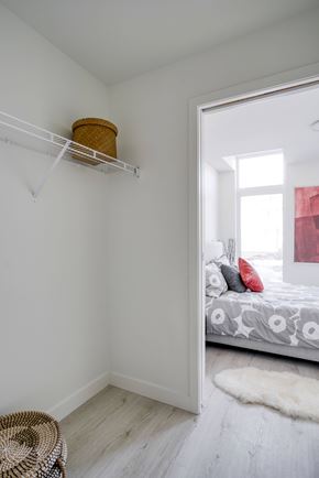 Winnipeg apartment for rent - A white bedroom with a bed and a basket on the shelf.
