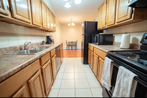 Thompson apartment for rent - A kitchen with wooden cabinets and a black refrigerator.