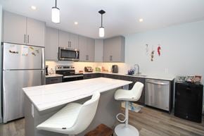 Ile Des Chenes townhouse for rent - A modern kitchen with a white table and chairs.