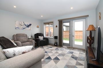 Ile Des Chenes townhouse for rent - A living room with a grey couch and a checkered floor.