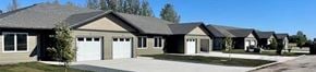 Ile Des Chenes townhouse for rent - A series of houses with garages are lined up in a row.