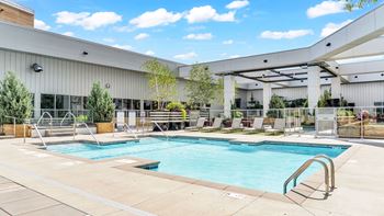A large outdoor swimming pool with a building in the background.