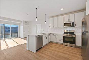 A modern kitchen with stainless steel appliances and white cabinets.