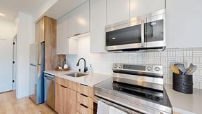 St. Paul apartment for rent - A modern kitchen with a stainless steel oven and microwave above the counter. at The Mason, St. Paul, MN, 55114