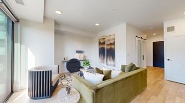 St. Paul apartment for rent - A modern living room with a green couch and a large abstract painting on the wall.